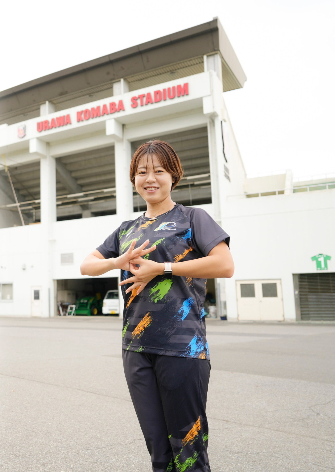 URAWA KOMABA STADIUMの前でポーズをとる門脇さん